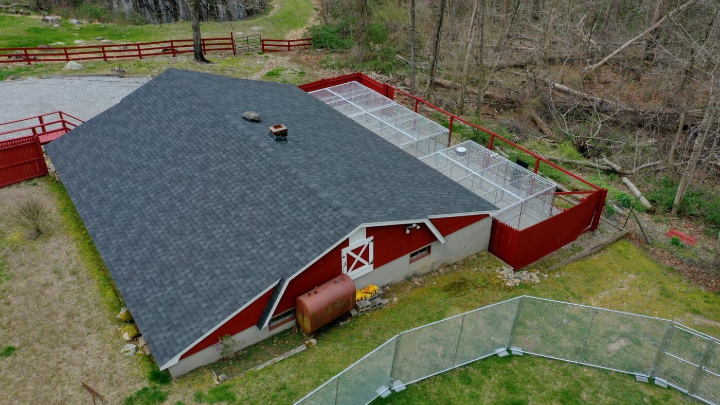 aerial view of red building with outdoor dog kennels inside red fence